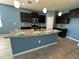 Spacious kitchen featuring an island with granite countertops, stainless steel appliances, and dark cabinets at 10621 Scenic Hollow Dr, Riverview, FL 33578