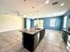 Open-concept kitchen with an island, granite countertops, stainless steel appliances, and seamlessly flowing living area at 10621 Scenic Hollow Dr, Riverview, FL 33578