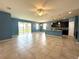 Bright, open-concept living room with tiled floors, ceiling fan, and seamless access to the kitchen and backyard at 10621 Scenic Hollow Dr, Riverview, FL 33578