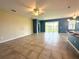 Bright, open-concept living room with tiled floors, ceiling fan, and seamless access to the kitchen and backyard at 10621 Scenic Hollow Dr, Riverview, FL 33578