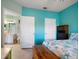 Bright bedroom featuring a view into the bathroom, turquoise walls, and tile floors at 10764 70Th Ave # 4305, Seminole, FL 33772