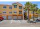 Exterior of condo building featuring assigned parking and garages with balconies and tropical landscaping at 10764 70Th Ave # 4305, Seminole, FL 33772
