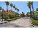 Community entrance with brick-paved road and lush tropical landscaping at 10764 70Th Ave # 4305, Seminole, FL 33772