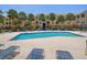 Community pool with comfortable lounge chairs with seating and palm trees in background at 10764 70Th Ave # 4305, Seminole, FL 33772