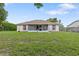 Spacious backyard featuring a screened-in patio and green lawn, ideal for outdoor living at 11251 Pickford St, Spring Hill, FL 34609