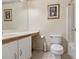 Bathroom with a vanity, toilet, decorative wallpaper border, and framed artwork at 11251 Pickford St, Spring Hill, FL 34609
