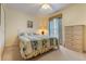 Cozy bedroom with a queen bed, dresser, and window with striped curtains at 11251 Pickford St, Spring Hill, FL 34609