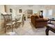 Open-concept dining area with tiled floors, a glass table, seating for four, and a view into the living space at 11251 Pickford St, Spring Hill, FL 34609