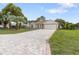 Inviting single-story home boasts a long brick driveway, well-kept lawn, mature trees and an attached garage at 11251 Pickford St, Spring Hill, FL 34609
