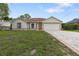 Inviting one-story home with manicured lawn, charming landscaping, and brick-paved driveway at 11251 Pickford St, Spring Hill, FL 34609