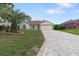Charming single-story home with manicured lawn, landscape beds, and brick-paved driveway at 11251 Pickford St, Spring Hill, FL 34609