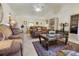 Relaxing living room with vaulted ceiling, a ceiling fan, tile flooring, and a large window for natural light at 11251 Pickford St, Spring Hill, FL 34609