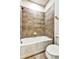 Bathroom with shower featuring tiled walls, a white tub, and a toilet at 11613 Sweet Tangerine Ln, Tampa, FL 33626