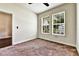 Empty bedroom featuring neutral carpet, base molding, and view from two windows at 11613 Sweet Tangerine Ln, Tampa, FL 33626