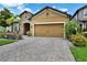 Attractive home with a two-car garage, brick-paved driveway, and well-maintained landscaping at 11613 Sweet Tangerine Ln, Tampa, FL 33626