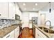 Modern kitchen featuring white cabinetry, stainless steel appliances, granite countertops and a decorative tile backsplash at 11613 Sweet Tangerine Ln, Tampa, FL 33626
