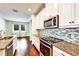 Bright eat-in kitchen featuring granite countertops, stainless steel appliances, and a stylish backsplash at 11613 Sweet Tangerine Ln, Tampa, FL 33626