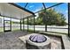 Screened-in patio area with stone pavers and a built-in fire pit, perfect for outdoor enjoyment at 11613 Sweet Tangerine Ln, Tampa, FL 33626