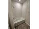 Bathroom with white tiled combined shower/tub and wood look flooring at 11634 Woodleaf Dr, Bradenton, FL 34211