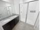 Modern bathroom with double sinks, granite countertops, and a glass-enclosed shower at 11634 Woodleaf Dr, Bradenton, FL 34211