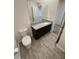 Bathroom with granite countertop vanity, white sink, tile flooring, and toilet at 11634 Woodleaf Dr, Bradenton, FL 34211