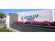 Community entrance sign landscaped with vibrant flowers and lush greenery at 11634 Woodleaf Dr, Bradenton, FL 34211