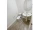 Stylish half bathroom with modern fixtures, pedestal sink, and tile flooring at 11634 Woodleaf Dr, Bradenton, FL 34211