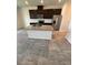 A kitchen boasts an island with granite countertops, a stainless steel refrigerator, and dark cabinets at 11634 Woodleaf Dr, Bradenton, FL 34211