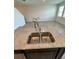 The kitchen island features granite countertops, a stainless double sink, and an open view to the living area at 11634 Woodleaf Dr, Bradenton, FL 34211