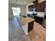 A modern kitchen featuring stainless appliances, granite counter tops, and a large kitchen island with a sink at 11634 Woodleaf Dr, Bradenton, FL 34211
