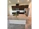 Kitchen features stainless steel appliances, dark cabinetry, and a large island with granite countertops at 11634 Woodleaf Dr, Bradenton, FL 34211
