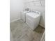 Bright laundry room featuring a full-size washer, dryer, and convenient wire shelving at 11634 Woodleaf Dr, Bradenton, FL 34211