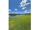 Scenic pond surrounded by grassy area and well-maintained community buildings under partly cloudy skies at 11634 Woodleaf Dr, Bradenton, FL 34211
