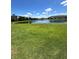 Lush green grass leading to pond and community buildings under a sunny, partly cloudy sky at 11634 Woodleaf Dr, Bradenton, FL 34211