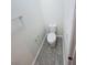 A simple powder room with white toilet, gray flooring, and chrome fixtures providing necessary functionality at 11634 Woodleaf Dr, Bradenton, FL 34211