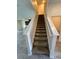 Carpeted stairs feature white banisters that provide a modern touch at 11634 Woodleaf Dr, Bradenton, FL 34211