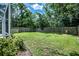 Large grassy backyard with wood fence and lush landscaping at 11837 Derbyshire Dr, Tampa, FL 33626