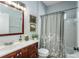 Cozy bathroom offers a vanity with granite countertop, framed mirror and shower with decorative curtain at 11837 Derbyshire Dr, Tampa, FL 33626