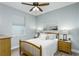 This bedroom features a wood frame bed, ceiling fan, and a window that brings in natural light at 11837 Derbyshire Dr, Tampa, FL 33626