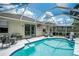 The pool, surrounded by a screened-in enclosure, offers a view of the patio and landscaped backyard at 11837 Derbyshire Dr, Tampa, FL 33626