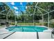 This fenced-in pool features a clear blue pool, green backyard, and screened-in enclosure at 11837 Derbyshire Dr, Tampa, FL 33626