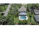 An aerial view showcases the home with a pool and lush greenery in a suburban setting at 1310 Rustlewood Dr, Brandon, FL 33510