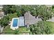 An aerial view showcases the home with a pool and lush greenery in a suburban setting at 1310 Rustlewood Dr, Brandon, FL 33510
