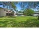 Large backyard with a beautiful pool, screened-in porch, lush lawn, mature trees, and privacy fencing at 1310 Rustlewood Dr, Brandon, FL 33510