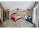 Bedroom with carpet flooring, ceiling fan, bed, desk, and an ensuite bathroom at 1310 Rustlewood Dr, Brandon, FL 33510