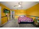Bright bedroom featuring yellow walls, carpet flooring, ceiling fan, and television at 1310 Rustlewood Dr, Brandon, FL 33510