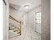 Tiled entryway featuring staircase with carpeted steps and white wooden railing at 1310 Rustlewood Dr, Brandon, FL 33510