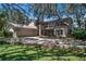 Charming two-story home with a balcony, attached garage, and driveway partially shaded by mature trees at 1310 Rustlewood Dr, Brandon, FL 33510