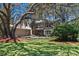 A charming two-story home features a balcony, an attached garage, and is shaded by mature trees at 1310 Rustlewood Dr, Brandon, FL 33510