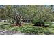 A charming two-story home features a balcony, an attached garage, and is shaded by mature trees at 1310 Rustlewood Dr, Brandon, FL 33510